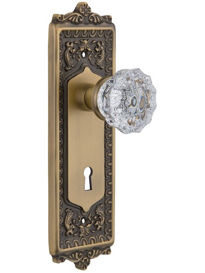 Egg and Dart Style Mortise Lock Set with Fluted Crystal Door Knobs In Antique Brass.
